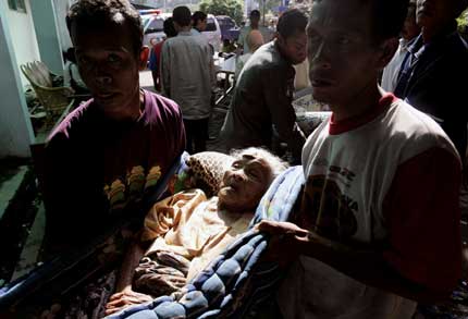 An earthquake victim is carried into a hospital in Yogyakarta, central Java, May 29, 2006. Aid was trickling in on Monday for survivors of an earthquake that killed more than 5,000 people on Indonesia's Java island and left tens of thousands of homeless foraging for food and shelter.