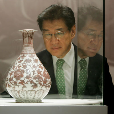 Theow Tow, Deputy Chairman of Christie's Asia and the Americas International Director of Chinese works of Arts, looks at an early Ming underglaze copper-red vase after it was sold for a world record of US$10,122,558 for any Ming porcelain during an auction in Hong Kong May 30, 2006. 