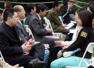 Pairs of single men and women hold a 8-minute-talk face to face during a matchmaking activity in Shanghai's Zhongshan Park on October 22, 2005. [newsphoto]