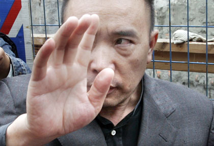 Accused smuggling kingpin Lai Changxing, one of China's most wanted fugitives, gestures while talking to media outside his residence in Vancouver, British Columbia June 1, 2006. Lai, who fled to Canada in 1999 with his family, claims he would be tortured or executed if returned to China and a Canadian judge agreed to delay his deportation while he challenges a ruling by Canadian immigration officials. 