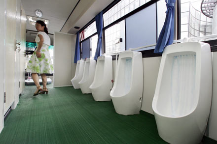 A visitor views the inside of an ecological and environmental friendly mobile toilet bus, during the Saving Water Toilet Exhibition for the Beijing Olympics in Beijing June 7, 2006. The exhibition showcased a range of prototype urinals, bowls, and traditional Asian crouching platforms -- all aimed at having a more positive impact on the environment. 