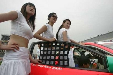 Pit girls pose for a photo before the Asian Touring Car Championship (ATCC) during 2006 Asian Festival of Speed (AFOS) in Beijing, June 11, 2006. The Beijing leg of the Asian Festival of Speed had fast cars, scantily-clad pit girls, high speed crashes and other things pleasing to track-side spectators. Picture taken June 11, 2006. [Reuters]