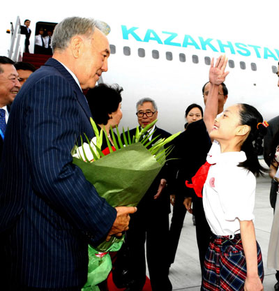 Kazakh President Nursultan Nazarbayev (L) is greeted by a Chinese girl upon his arrival at the Pudong International Airport in Shanghai, east China on June 13, 2006. (Xinhua