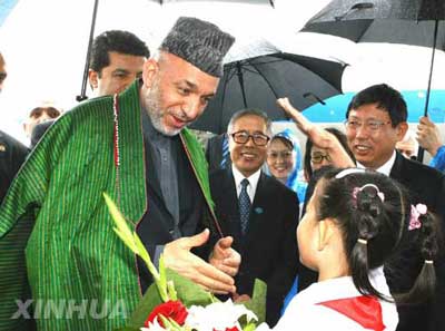 Afghan President Hamid Karzai (L, front) is greeted by a Chinese girl upon his arrival at the Pudong International Airport in Shanghai, east China on June 14, 2006. Karzai is here to attend the summit of the Shanghai Cooperation Organization (SCO) as guest of the host country.
