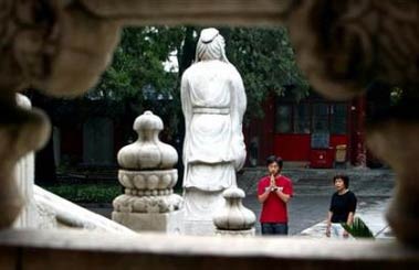A high school student (L) prays with his mother in front of a statue of Confucius at the Confucius Temple in Beijing in a June 5, 2003 file photo. Chinese claiming Confucius for an ancestor can now use a genetic test to prove a direct blood connection to the grandfather of Chinese social mores, a state newspaper said Friday.