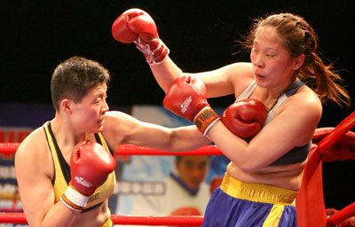 Chinese boxer Wang Yayin (L) punches Xu Dan in a game in Shanghai April 29, 2006. [Xinhua]