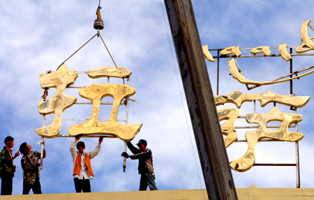 Chinese workers install the sign on the roof of Lhasa Railway Station in Lhasa