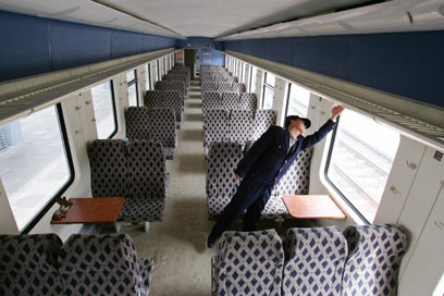 A worker checks the carriage of a train for the Qinghai-Tibet Railway in Xining, west China's Qinghai province, June 12, 2006. The Qinghai-Tibet Railway will begin trial operations on July 1, 2006. Picture taken June 12, 2006. [Reuters]