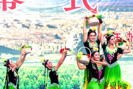 Uygur girls perform dances at the opening ceremony of the third Xinjiang International Tourism Festival as well as the 15th China Silk Road Turpan Grape Festival Wednesday, June 28, 2006. The event will last two months until August 28, 2008. [newsphoto]
