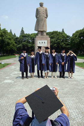 A student takes a picture of his friends in front of the Chinese flag during a graduation ceremony at Fudan University in Shanghai June 28, 2006.[
