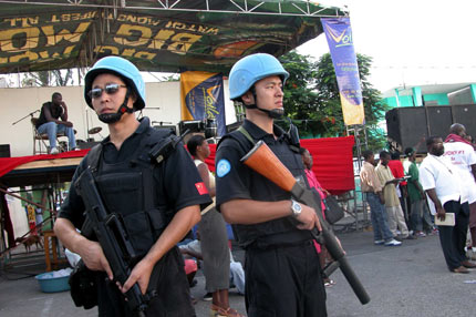 Armed UN Chinese peacekeepers stand guard near a church during a religious celebration of the local residents in Port-au-Prince, the Haitian Capital, June 27, 2006. Currently, there are 125 Chinese peacekeepers in Haiti. [Newsphoto]