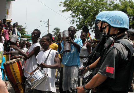 Armed UN Chinese peacekeepers stand guard near a church during a religious celebration of the local residents in Port-au-Prince, the Haitian Capital, June 27, 2006. Currently, there are 125 Chinese peacekeepers in Haiti. [Newsphoto]