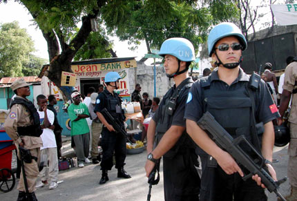 Armed UN Chinese peacekeepers stand guard near a church during a religious celebration of the local residents in Port-au-Prince, the Haitian Capital, June 27, 2006. Currently, there are 125 Chinese peacekeepers in Haiti. [Newsphoto]