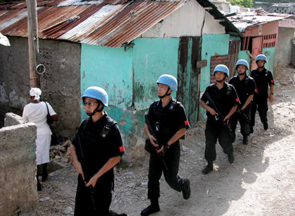 Armed UN Chinese peacekeepers patrol near a church during a religious celebration of the local residents in Port-au-Prince, the Haitian Capital, June 27, 2006. Currently, there are 125 Chinese peacekeepers in Haiti. [Newsphoto]