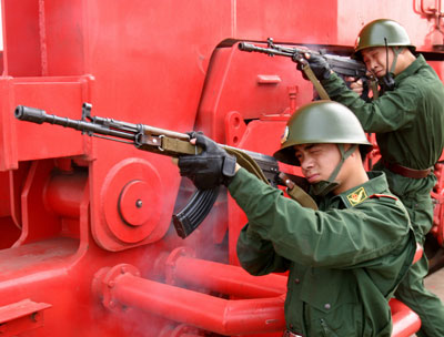 Chinese coast guards take part in an anti-hijack exercise at a port in Lianyungang, East China's Jiangsu Province June 29, 2006. The exercise in which a passenger liner was taken hostage by "gunmen" aimed to test the coast guards' capability to deal with emergencies. [newsphoto]
