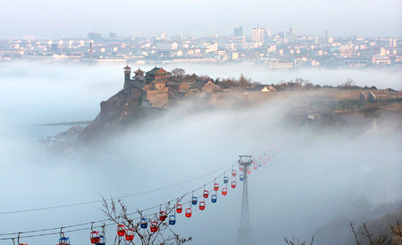 Penglai, a coastal city in east China's Shandong Province, is blanketed in thick advection fog on Monday morning, July 3, 2006. The spectacular scenery lasted two hours, attracting many tourists and local residents. [newsphoto]