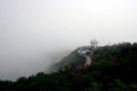 Penglai, a coastal city in east China's Shandong Province, is blanketed in thick advection fog on Monday morning, July 3, 2006. The spectacular scenery lasted two hours, attracting many tourists and local residents. [newsphoto]
