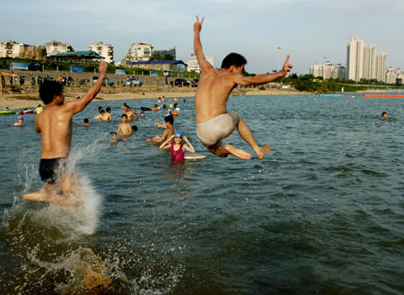 Local residents play in the water to cool themselves off in Fuzhou, capital of east China's Fujian Province Monday, Junly 3, 2006. A heat wave is expected to hit parts of China over the next week with temperatures reaching up to 37 Degree Celsius (98 degrees Fahrenheit). [Xinhua]