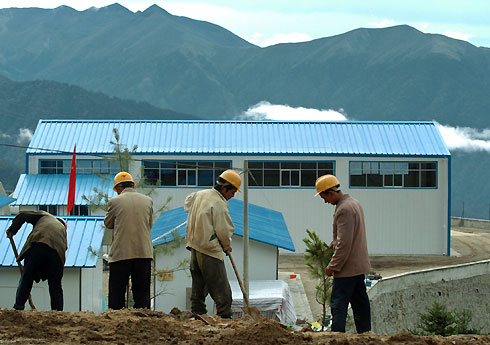 Men plant trees in front of Renqinggang border trade market, which will be opened on July 6, in Yadong county in the Tibetan Autonomous Region, July 2, 2006. China opened the world's highest railway on Saturday, which is expected to promote social development, economy and trade between Tibet with other parts of China.