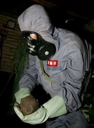An expert from the Office of the Chinese Ministry of Foreign Affairs for Chemical Weapons Abandoned by Japan in China, and soldiers, pack bombs dug out at an excavation site of World War Two chemical weapons abandoned by Japan, in Ning'an, China's Heilongjiang province, July 5, 2006. The two countries disagree on the scale of corroding weapons left behind by Japan's army after the World War, with China saying there are 2 million shells to be dealt with, while Japan puts the figure in the hundreds of thousands.