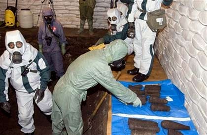 Chinese and Japanese chemical weapons experts in protective clothing dig up abandoned poison gas bombs in a pit in Ning'an, northeastern China's Heilongjiang province, Wednesday, July 5, 2006. The joint Chinese-Japanese team was preparing Wednesday to excavate abandoned Japanese poison gas bombs from World War II that were buried near a school after a factory received them as scrap metal. (AP Photo