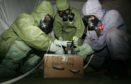 An expert from the Japanese Abandoned Chemical Weapons Office packs a bomb dug out and marked at an excavation site of World War Two chemical weapons abandoned by Japan, in Ning'an, China's Heilongjiang province, July 5, 2006. The two countries disagree on the scale of corroding weapons left behind by Japan's army after the World War, with China saying there are 2 million shells to be dealt with, while Japan puts the figure in the hundreds of thousands.