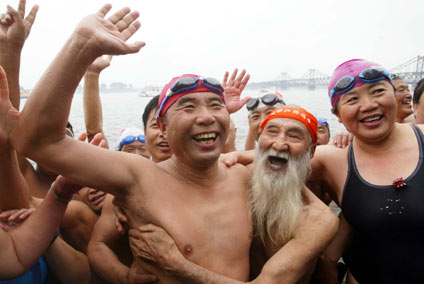 Wang Gangyi, a famous adventurer, is welcomed by fellow cold-water swimmers on the Yalu River in Dandong, Liaoning Province, on Saturday.