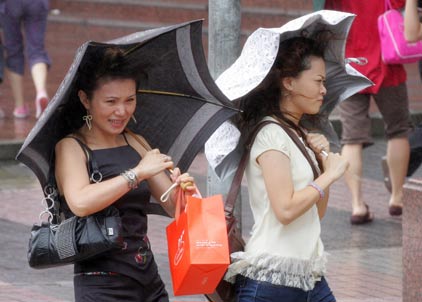 Pedestrians are buffeted by heavy rains and strong winds from tropical storm Bilis in front of a train station in Taipei July 13, 2006. [Reuters]