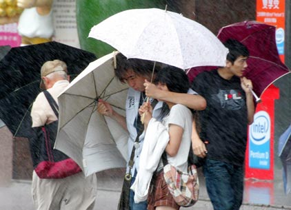 Pedestrians are buffeted by heavy rains and strong winds from tropical storm Bilis in front of a train station in Taipei July 13, 2006. [Reuters]