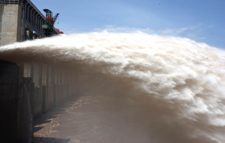 Floodwater gushes out from the eight-hole sluice gate on the Three Gorges Dam Tuesday, July 18, 2008. The hydro-power project, the world's largest of its kind, has played an active role in storing the floodwater and lagging flood peak during the summer flood season ever since the tearing down of the cofferdam on June 6 this year. It is the first time the sluice gate was raised to release floodwater from the reservoir. [newsphoto]