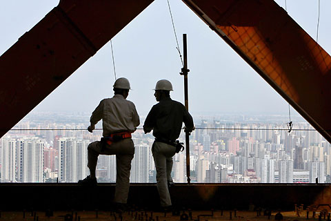 Construction workers chat on the 42nd floor of the Shanghai World Financial Center building site in Shanghai July 24, 2006. The building, which will stand at 101 storeys and 492 metres when completed in 2008, aims to be the tallest building in China. [Reuters]