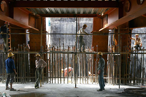 Construction workers chat on the 42nd floor of the Shanghai World Financial Center building site in Shanghai July 24, 2006. The building, which will stand at 101 storeys and 492 metres when completed in 2008, aims to be the tallest building in China. [Reuters]