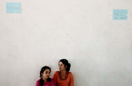 Canadian Raymonda Kadamani (R) and her daughter Sharon sit inside a camp set at a school in Larnaca, Cyprus July 24, 2006. A Cypriot police spokesman told Reuters the total number of evacuees arriving in the holiday island had reached 35,000 by Monday morning. Of those, 23,000 had already travelled home. [Reuters] 