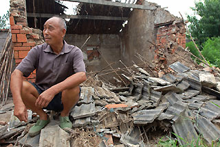 A man sits amid the rubble of his pigsty which was destroyed by an earthquake in Dingyuan, East China's Anhui Province, yesterday. The quake, which measured 4.2 on the Richter scale, hit Dingyuan in the morning but no casualties have been reported. (Reuters)