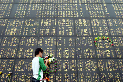 A young man places flowers at a monument in Tangshan yesterday to mourn the more than 240,000 victims of the 1976 earthquake. Today is the 30th anniversary of the disaster.