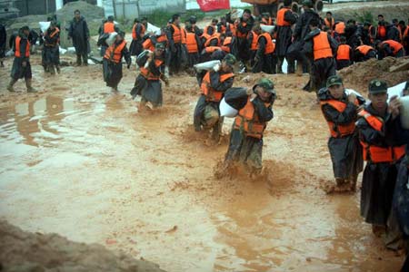 Soldiers repair the destroyed dam in Jinjiang, East China's Fujian Province July 25, 2006. [Xinhua]