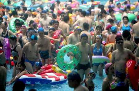 Thronging swimmers stand in Taiyanggong Swimming Pool in Nanjing, capital of east China's Jiangsu Province Sunday, July 30, 2006, as the local temperature hit 36.2 degrees centigrade. With the abundant people going there to beat the heat, swimmers can only stand in the water rather than swim freely. [IC]
