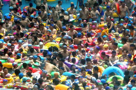 Thronging swimmers stand in Taiyanggong Swimming Pool in Nanjing, capital of east China's Jiangsu Province Sunday, July 30, 2006, as the local temperature hit 36.2 degrees centigrade. With the abundant people going there to beat the heat, swimmers can only stand in the water rather than swim freely. [IC]