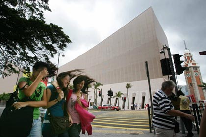 Women walk through the wind in front of the Hong Kong Cultural Centre in Hong Kong August 3, 2006. Typhoon Prapiroon, which killed six people and forced thousands to flee their homes in the northern Philippines, churned towards southern China on Thursday and tens of thousands were evacuated ahead of its arrival. [Reuters]