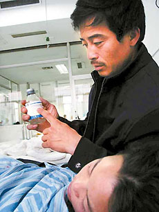 The father of a patient holds a bottle of clindamycin phosphate glucose at the No 2 Hospital Affiliated to Harbin Medical University on Thursday night. 