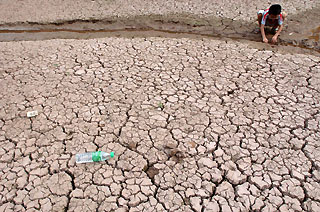 A boy plays on a dried-up river bed in southwest China's Chongqing municipality, August 18, 2006. At least 14 million people and 15 million livestock are suffering from a shortage of drinking water as continuous droughts and searing heat ravage western China, Xinhua News Agency reported.