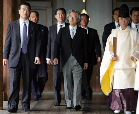 Japan's Prime Minister Junichiro Koizumi (C) is led by a Shinto priest (R) as he visits Tokyo's Yasukuni shrine August 15, 2006. [Reuters]