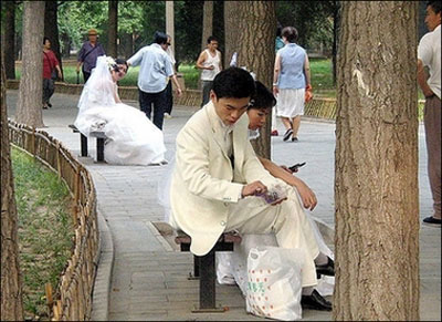 Wedding couples rest on park benches as they wait for their turn to be photographed, in Beijing in 2003. China's economic hub Shanghai has trained its first group of marriage counselors, state media said, as the city experiences one of the highest divorce rates in the country. [AFP]