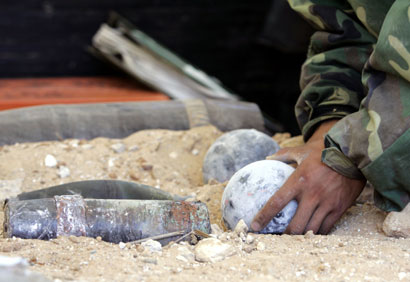 A Chinese soldier from the U.N international peacekeeping force holds unexploded Israeli ordnance which was removed from the southern village of Bayyada, near Tyre (Soure), August 28, 2006.