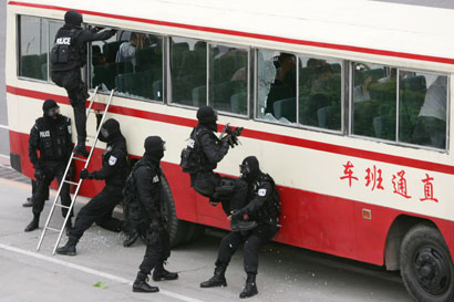 Paramilitary policemen practise during an anti-riot drill in Beijing August 29, 2006. The fight against "extremism, separatism and terrorism" is expected to take centre stage at a summit next month between judges from China, Russia and Central Asia, a Chinese official said on Tuesday. 