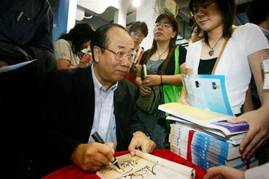 Former spokesman for Communist China's Cabinet and atheist Zhao Qizheng signs copies of the book he co-wrote with American evangelist and preacher Luis Palau at a signing for their book titled 'Riverside Talks: A Friendly Dialogue Between an Atheist and a Christian.' at a bookfair in Beijing, China Wednesday Aug. 30, 2006.