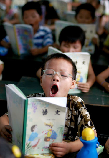 A pupil reads during a class at a primary school for the children of migrant labourer Nanjing, in east China's Jiangsu province, September 1, 2006. 