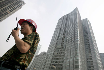 A worker uses a walkie-talkie at a construction site in China's capital Beijing May 18, 2006. 