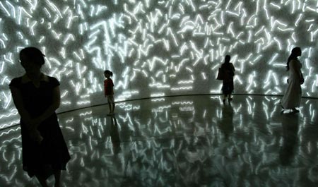 Visitors look at a piece of work of Chinese artist Shen Fan during the opening of the 6th Shanghai Biennial in Shanghai September 5, 2006. 