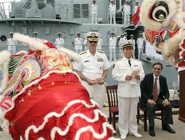 With the Chinese Naval missile cruiser, the Qingdao, in the background, Chinese lion dancers perform for U.S. Navy Rear Adm. Townsend G. Alexander, left, and Chinese Rear Adm. Wang Fushan, center, and Chinese Ambassador to the United States Zhou Wenzhong, Wednesday, Sept. 6, 2006, in Pearl Harbor, Hawaii. The Qingdao, a Luhu-class guided missile cruiser, and the Hongzehu, a refueling ship, arrived for four days of exercises, personnel exchanges, and touring.